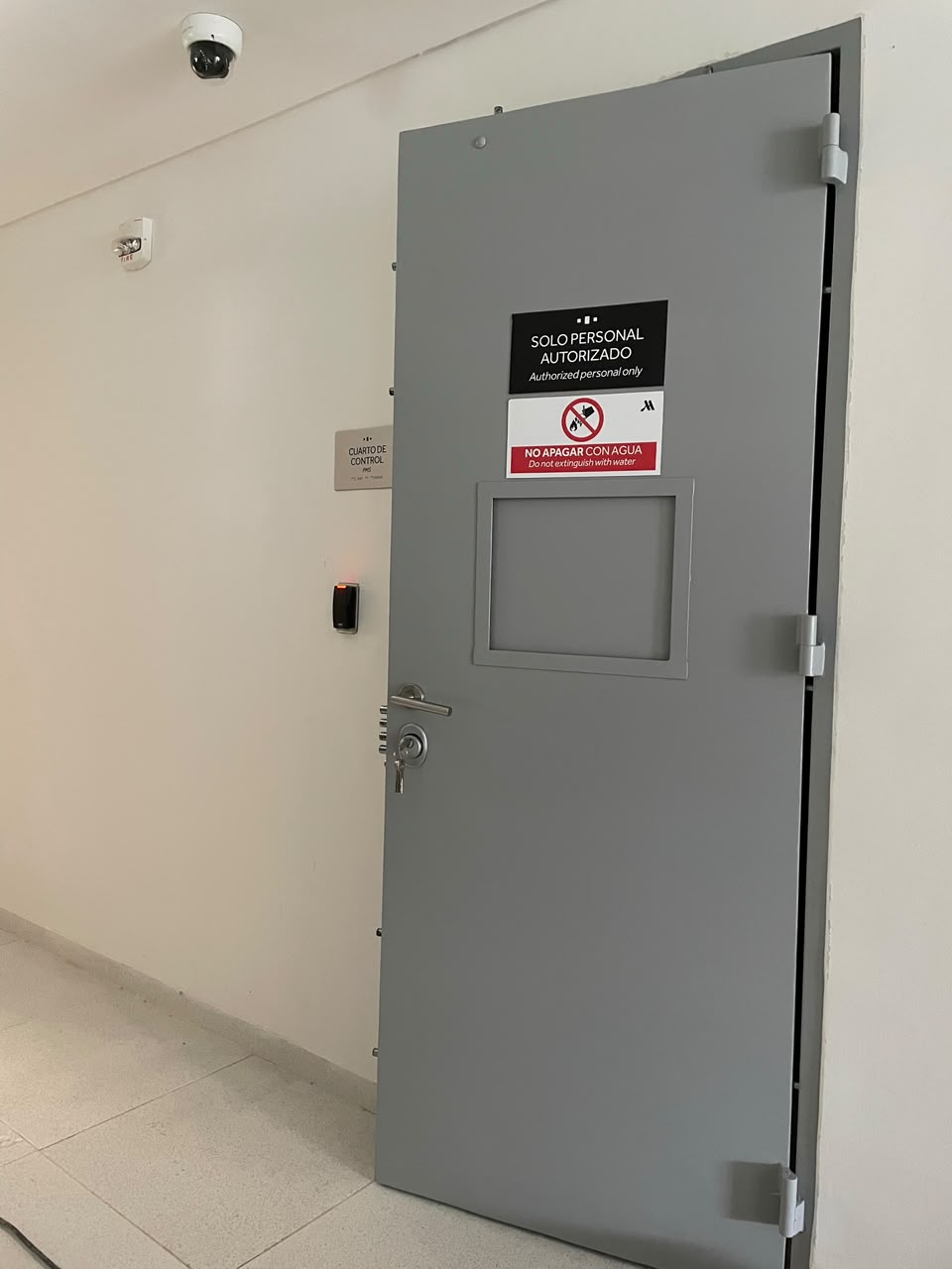 Puerta de seguridad gris para cuarto de control con visor, control de acceso y señalización