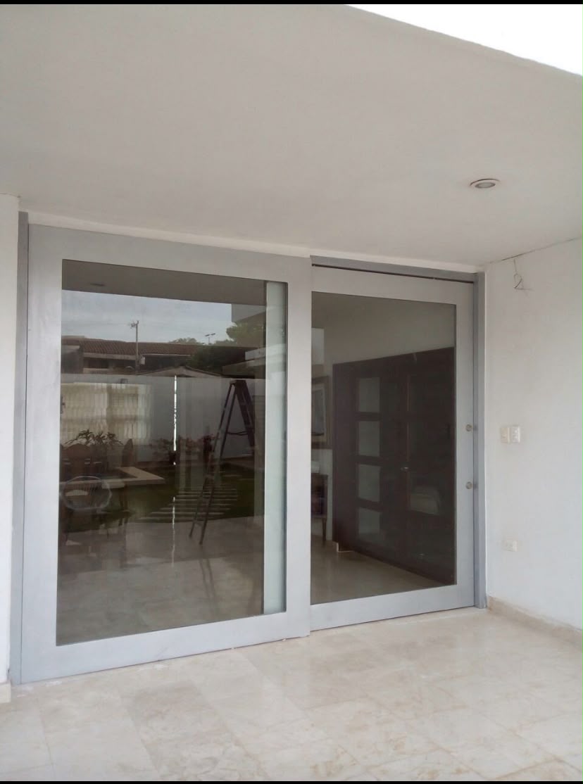 Fachada corrediza en vidrio templado con estructura de aluminio instalada en vivienda